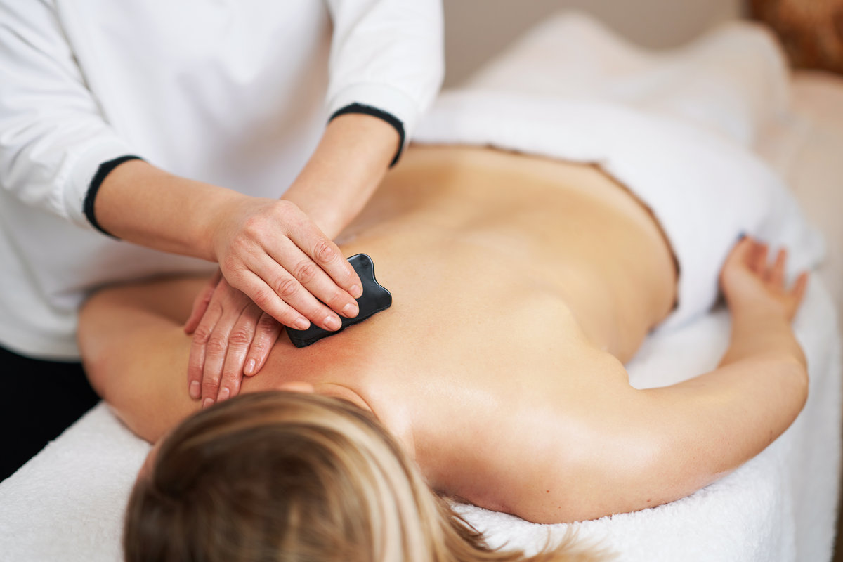 Woman having a gua sha massage in salon. High quality photo